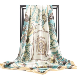 Detailed close-up of silk scarf with nautical anchors and compass print on white background