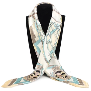 Close-up of nautical patterns with sailboats and anchors on a beige satin silk scarf