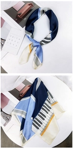 Detail of a piano keyboard pattern silk scarf in navy and light blue for elegant styling