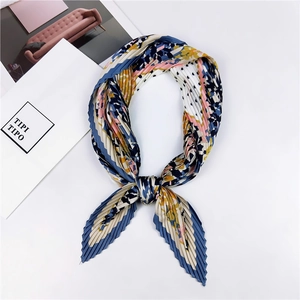 Détail d'un foulard en soie plissé avec des motifs floraux et géométriques colorés