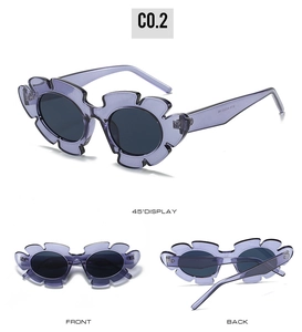 Detail view of purple flower-shaped sunglasses with translucent frames and dark lenses