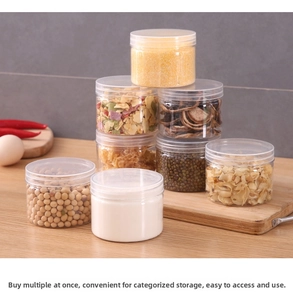 Clear plastic storage jars stacked on a wooden counter for organized kitchen pantry use