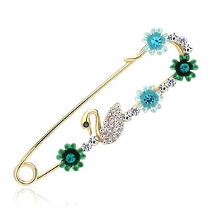Detailed view of swan and floral brooch with colorful crystals on golden safety pin