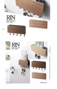 Detail view of magnetic wooden key holder with five metal hooks on an entryway door