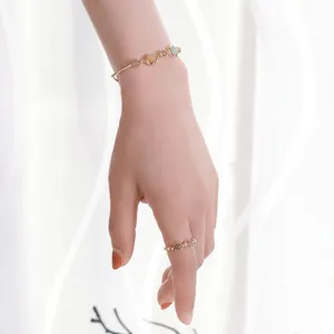 Detail eines eleganten Goldarmband- und Ring-Sets mit bunten Katzenaugen-Edelsteinen