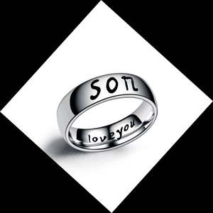 Macro shot of silver titanium steel ring with son and love you engraved on the band