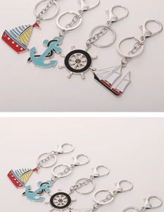 Macro view of colorful sailing anchor and helm metal keychains with enamel finish