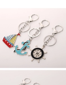Nautical metal keychains featuring enamel sailboat, blue anchor and black ship helm designs