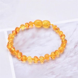 Detail of Baltic amber baby bracelet showing translucent yellow beads and screw clasp