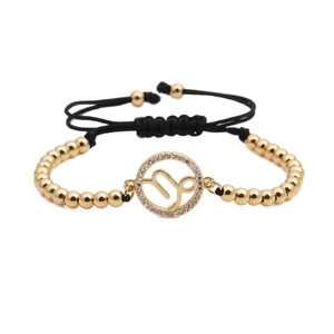 Close-up of golden beaded Capricorn bracelet with sparkling pavé zircons and woven cord