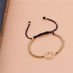 Detail of adjustable gold-beaded Leo zodiac bracelet with micro-pave cubic zirconia charm