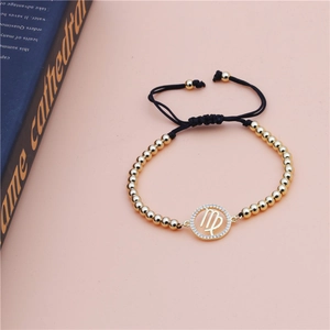Detail of Virgo constellation charm with micro-paved zircons on gold beaded bracelet