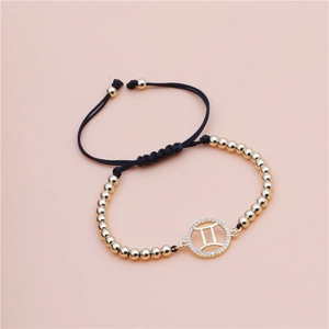 Detail of Gemini zodiac braided bracelet with gold beads and sparkling cubic zirconia