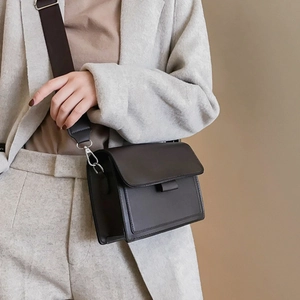 Classic dark brown crossbody bag with wide strap on beige blazer for a stylish daily look