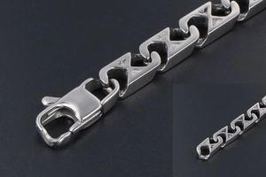 Detailed close-up of a silver S-link chain bracelet with a secure lobster clasp