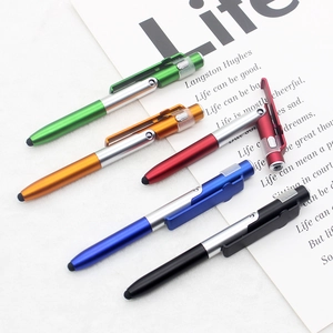 Flat lay of five colorful multifunctional pens with metal clips and stylus tips on paper