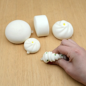 Slow rebound squishy toys shaped like steamed buns on a wooden table for stress relief