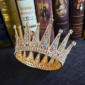 Vintage European bridal gold crown with sparkling rhinestones on antique book background