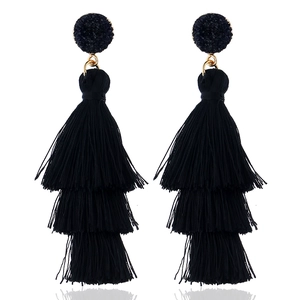 Detail view of elegant three-tier black fringe tassel earrings with black gemstones