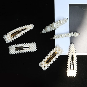 Detail of 6-piece pearl hair clip set with gold metal finish and white woven beads