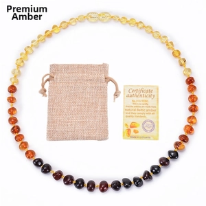 Detailed shot of multi-colored Baltic amber baby necklace with certificate and linen pouch