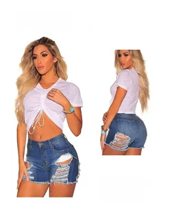 Nahaufnahme von weißem Crop-Top mit Kordelzug und Distressed-Denim-Shorts mit Fransen