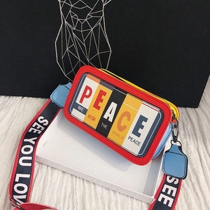 Détail du sac bandoulière en cuir multicolore avec sangle large et imprimé peace
