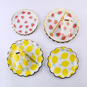 Detail of strawberry and lemon paper plates and cups with elegant gold wavy edges