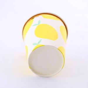 Close-up of disposable paper cups with yellow lemon patterns for party tableware