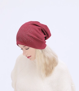 Close-up of wine red knitted beanie featuring sparkly silver rhinestones on a model