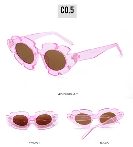 Detail view of pink flower-shaped jelly sunglasses with brown lenses and scalloped edges