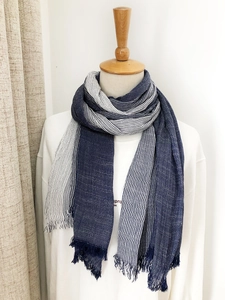 Detail view of blue and white striped cotton-linen scarf featuring elegant fringe tassels