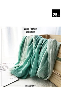 Close-up of a green and white striped cotton scarf draped over a wooden crate