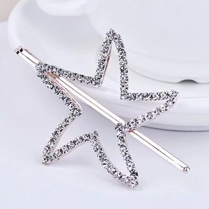 Détail macro de la barrette étoile argentée avec strass sur fond de porcelaine blanche