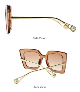 Detail view of tortoiseshell frame sunglasses with gold temples and pearl accents