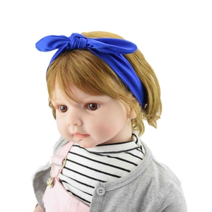 Front view of an infant mannequin wearing a blue elastic knotted bow headband for babies