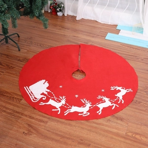 Red Christmas tree skirt with white reindeer and Santa sleigh prints on wooden floor