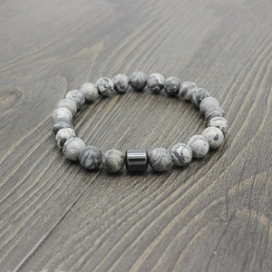 Detailed view of map stone and hematite beaded bracelet on a dark wood background