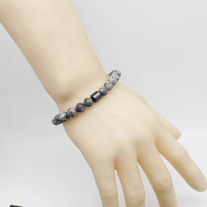 Close-up of stone beaded bracelet with tiger eye beads on a hand model with white background