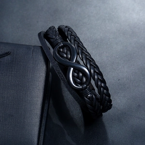 Multi-layer black leather braided bracelet with matte black infinity symbol on a black box