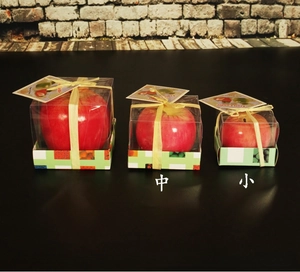 Tres tamaños de velas de manzana roja realistas en cajas con etiquetas de velas de fruta