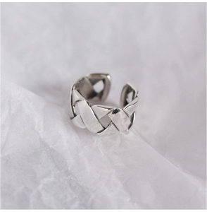 Close-up of woven design S925 sterling silver open ring with textured metallic finish