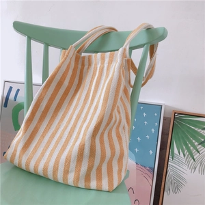 Macro detail of yellow and white striped canvas tote with durable herringbone weave texture