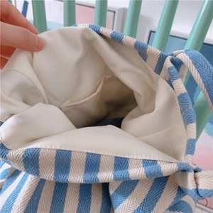 Close-up of blue and white striped canvas tote bag showing interior pocket and lining