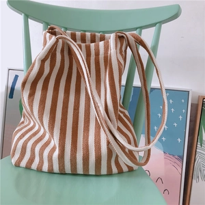 Detailed texture of thick striped canvas tote bag on a stylish light green chair