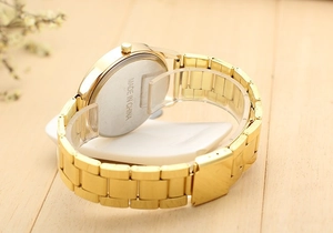 Vue arrière détaillée d'une montre à quartz dorée avec fond en acier et bracelet à maillons