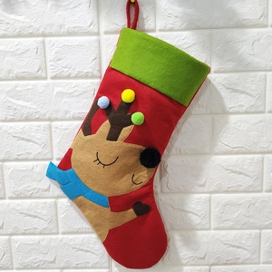 Détail d'une chaussette de Noël rouge et verte avec motif de renne en relief