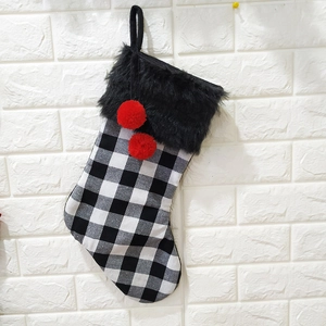 Détail de chaussette de Noël à carreaux noirs et blancs avec bordure en fausse fourrure
