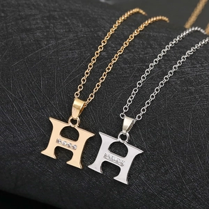 Close-up of gold and silver H-shaped pendant necklaces with tiny cubic zirconia stones