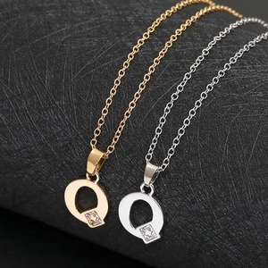 Macro detail of capital letter Q pendant with cubic zirconia on gold and silver chain